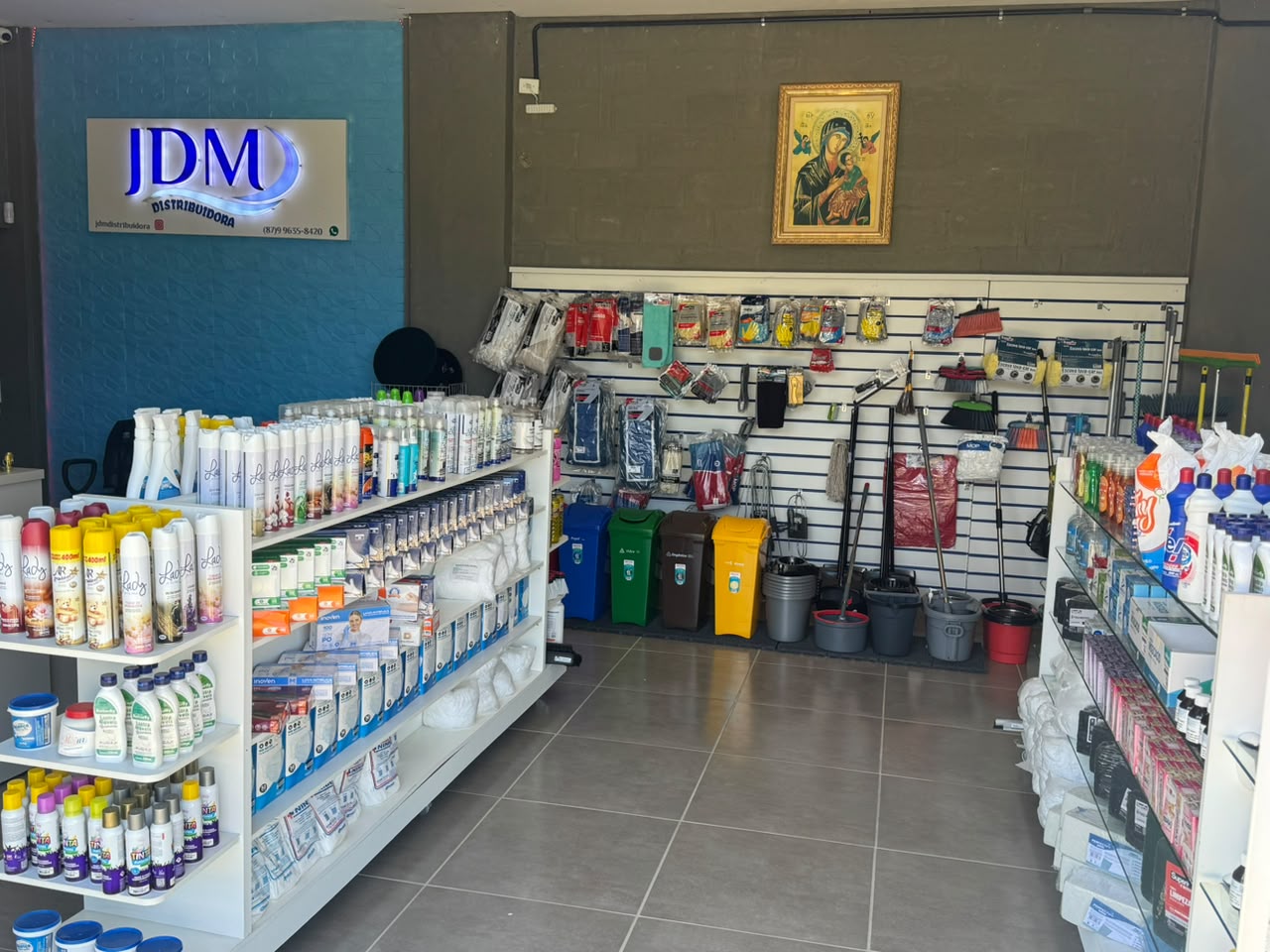 Interior da loja da JDM Distribuidora com prateleiras de produtos de limpeza